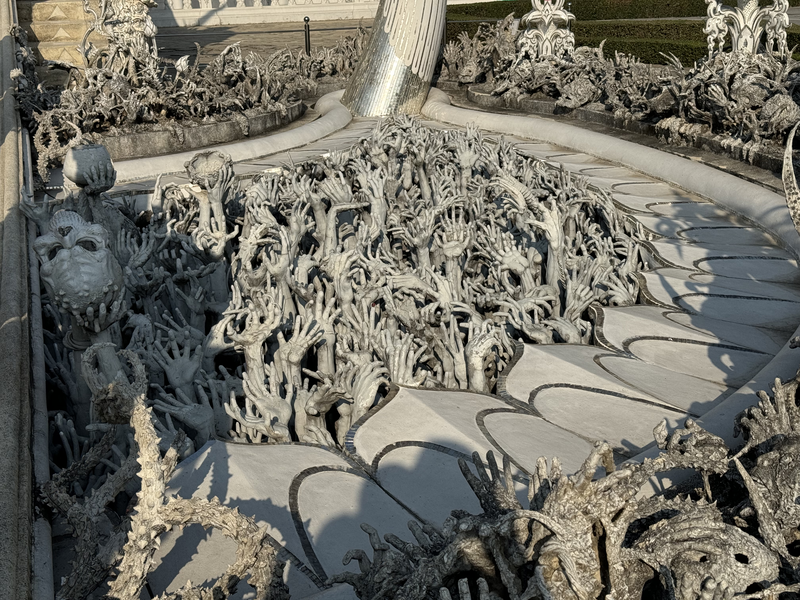Sculpture of hands reaching up from hell