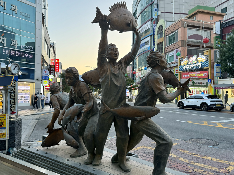 Statue of men ecstatically happy with their catch of fish